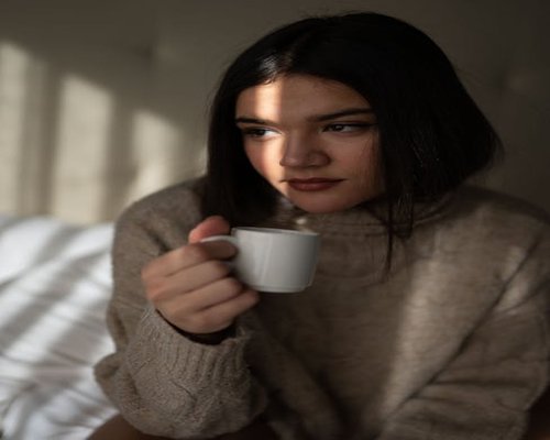 person enjoying morning coffee with soft sunlight