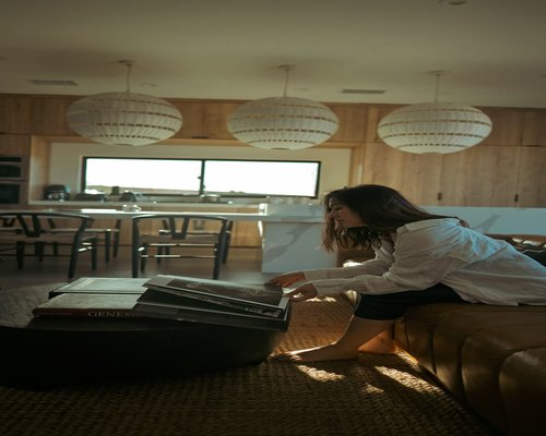 woman relaxing and reading a physical book in a cozy room